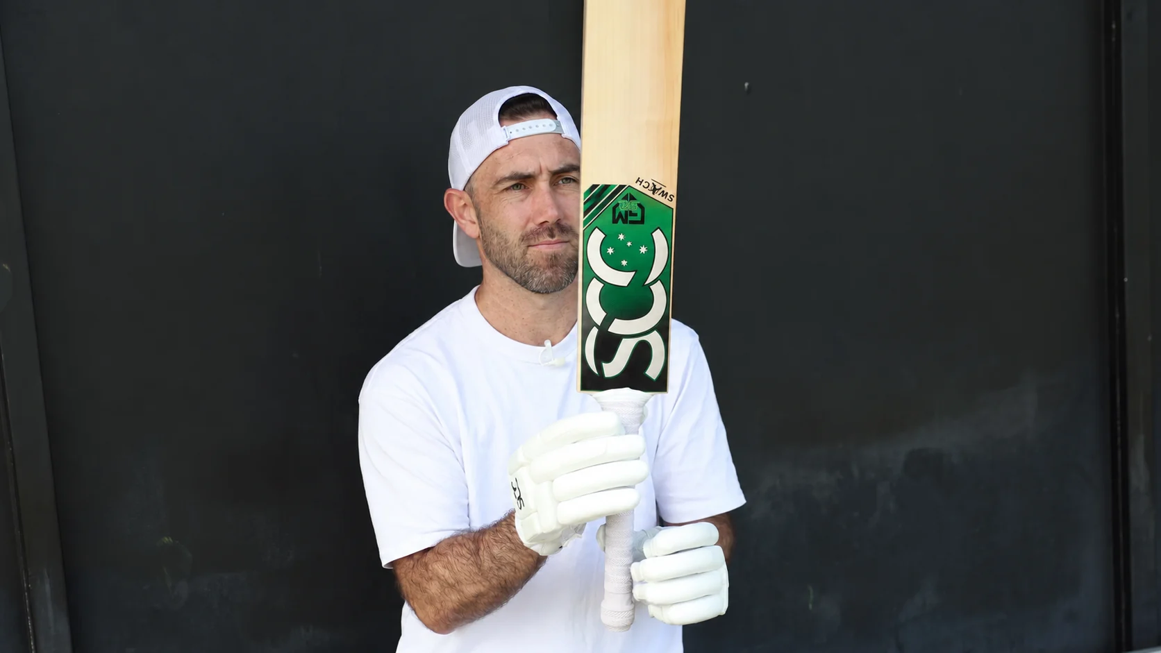 Glenn Maxwell holding a Southern Cross Cricket Switch bat